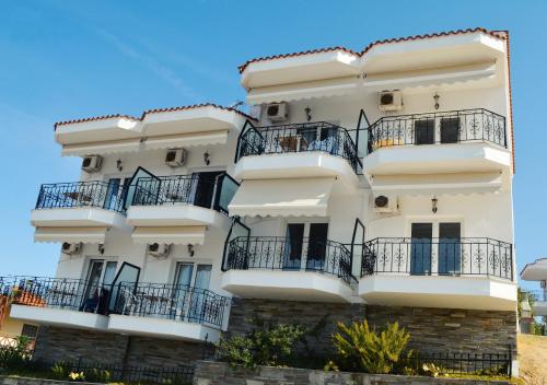 a white apartment building with balconies on it at Lazaridis Luxury Studios & Apartments in Nea Roda