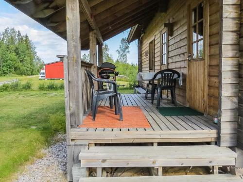 a porch of a cabin with two chairs and a table at Holiday Home Tuisku by Interhome in Punkalaidun