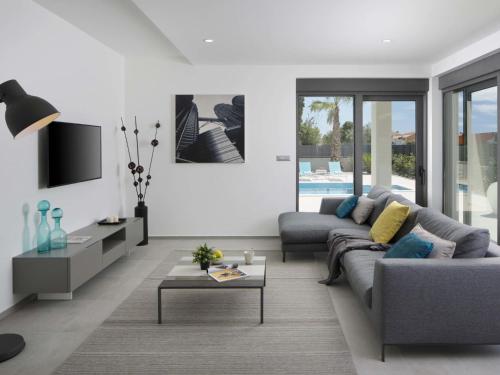 ein Wohnzimmer mit einem Sofa und einem Tisch in der Unterkunft Apartment Villa Fasana by Interhome in Fažana