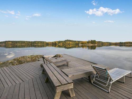 ein Holzsteg mit einer Bank und einem Stuhl an einem See in der Unterkunft Holiday Home Orava-apaja by Interhome in Pitkälahti