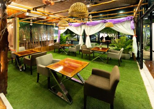 a restaurant with tables and chairs and purple curtains at Andalay Beach Resort Koh Libong in Ko Libong