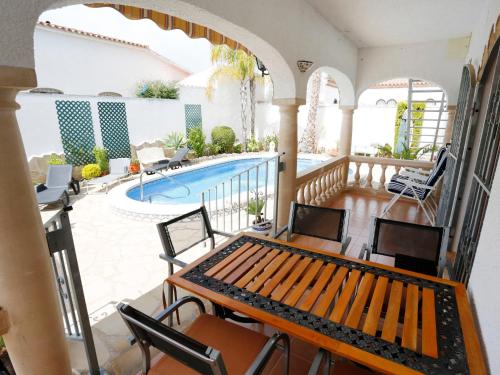 balcón con piscina, mesa y sillas en Villa Rustical Mont Roig by Interhome en Miami Platja