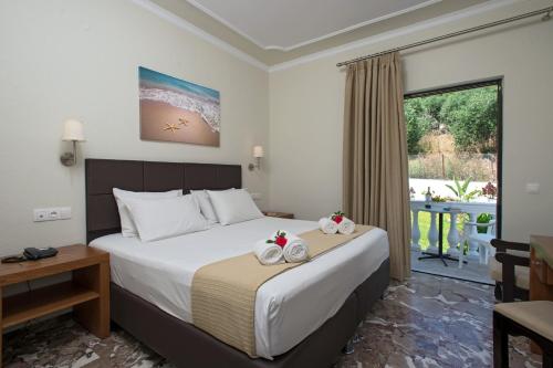 a bedroom with a bed with two towels on it at Hotel Kaiser Bridge in Benitses