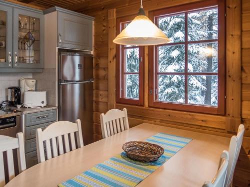 a kitchen and dining room with a table and chairs at Holiday Home Vaarapirtti - tähti by Interhome in Lahdenperä