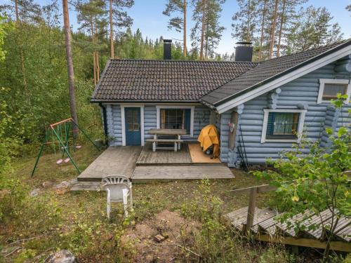 a blue house with a wooden porch and a picnic table at Holiday Home Harrila by Interhome in Huuhanaho