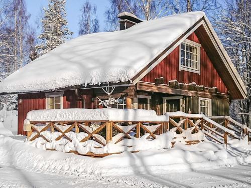 HaraにあるHoliday Home Talasniemi by Interhomeの森の雪に覆われた赤い小屋