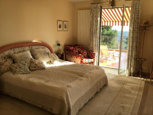 a bedroom with a bed and a sliding glass door at Luxurious sea view villa in Saint Paul de Vence in Saint-Paul-de-Vence