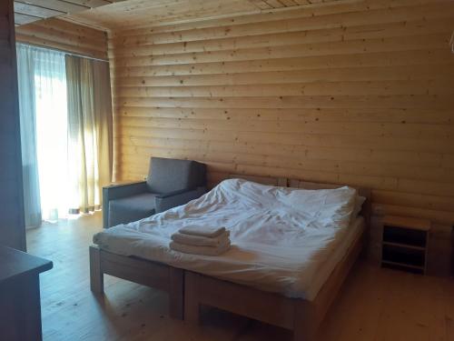 a bed in a room with a wooden wall at Біла хата in Iltsi