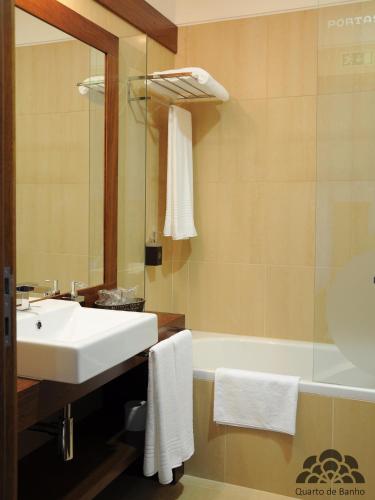 a bathroom with a sink and a bath tub at Hotel Portas De Santa Rita in Ermesinde