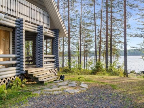 een blokhut met een veranda en uitzicht op het water bij Holiday Home Kissankello by Interhome in Ahmovaara
