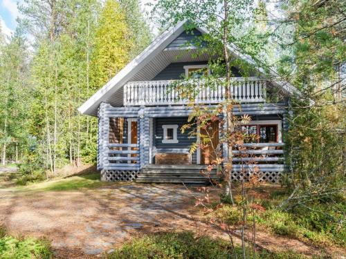 a blue log cabin in the woods with trees at Holiday Home Metsätähti by Interhome in Ahmovaara