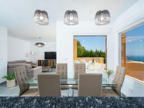 a dining room with a glass table and chairs at Apartment Miramar by Interhome in Moraira