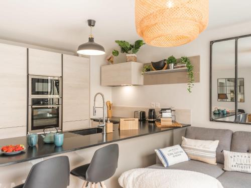 un salon avec un canapé et une cuisine dans l'établissement Apartment Les Terrasses de la Plage-2 by Interhome, à Quiberon