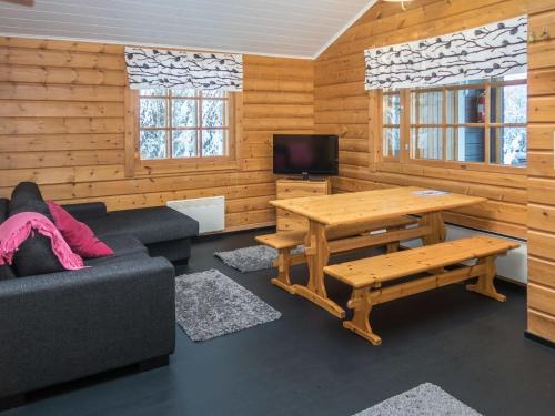 ein Wohnzimmer mit Sofa und Tisch in der Unterkunft Holiday Home Rukantaika 1b by Interhome in Virkkula