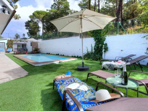 a backyard with a pool and a table with an umbrella at Holiday Home Paradis by Interhome in Mont Barbat