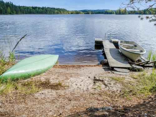 a boat on the shore of a lake with a dock at Holiday Home Kanerva by Interhome in Ahmovaara