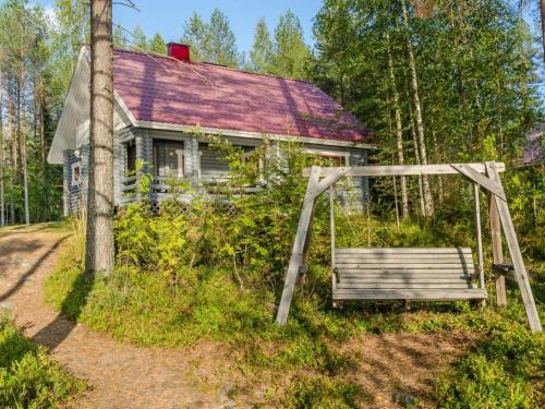 ein altes Haus mit einer Bank davor in der Unterkunft Holiday Home Kissankello by Interhome in Ahmovaara