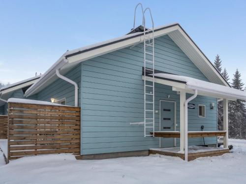 a blue house with a deck in the snow at Holiday Home Klz rodoniitti by Interhome in Vuokatti