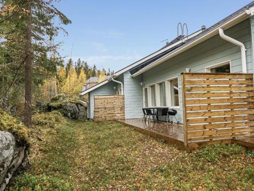 a house with a wooden deck with a table on it at Holiday Home Klz krysoliitti by Interhome in Vuokatti