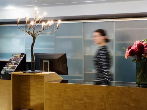 a woman walks past a checkout counter in a store at Boutique Hotel Helmhaus Zürich in Zurich
