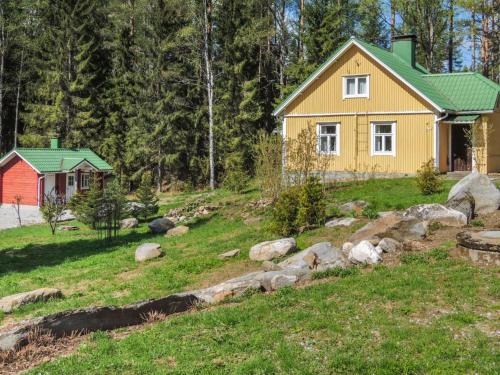 una casa amarilla con techo verde en un patio en Holiday Home Tyynelä by Interhome, en Varistaipale