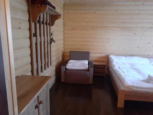 a room with two beds and a chair in it at Біла хата in Iltsi