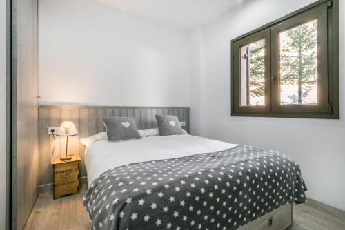 sypialnia z łóżkiem z czarno-białą kołdrą w obiekcie Adriana by Totiaran w mieście Baqueira-Beret