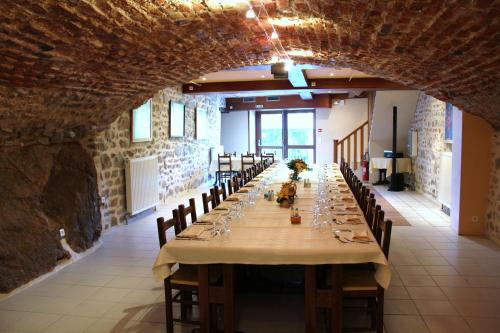 una lunga sala da pranzo con un lungo tavolo con sedie di Hostellerie du Forez a Saint-Galmier