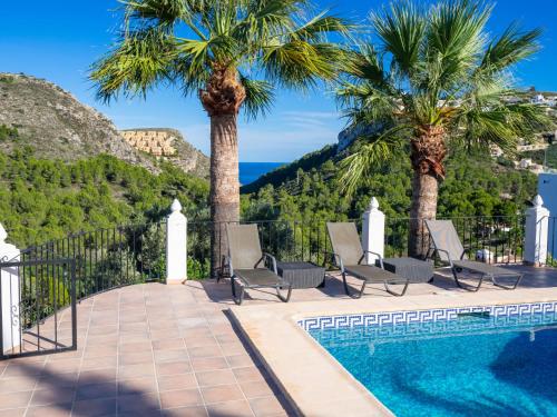 een villa met een zwembad en palmbomen bij Villa Manana by Interhome in Moraira