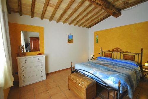 a bedroom with a bed and a dresser and a mirror at Agriturismo la Nicchia in Castelnuovo Berardenga