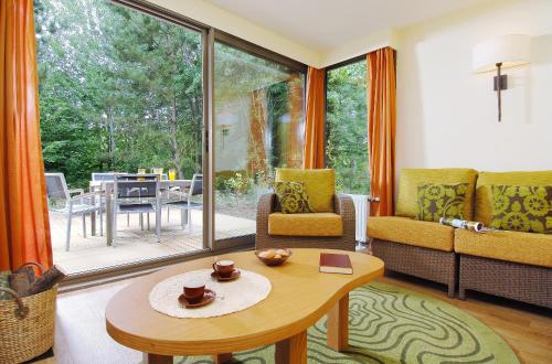 
a living room filled with furniture and a table at Center Parcs Les Bois Francs in Verneuil d'Avre et d'Iton
