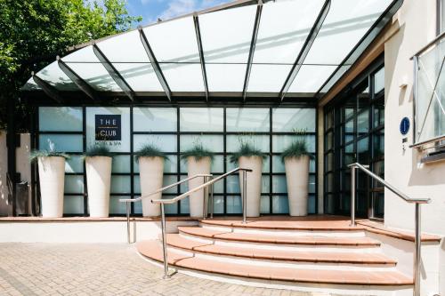 ein Glasgebäude mit einer Treppe davor in der Unterkunft The Club Hotel & Spa Jersey in Saint Helier Jersey