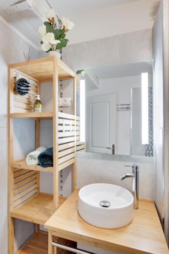 une salle de bain avec un lavabo et un miroir dans l'établissement Le Grand Mirebeau - Parking privé, à Bourges