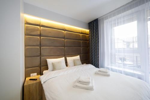 a bedroom with a large bed with two towels on it at Pure Apartments in Lviv