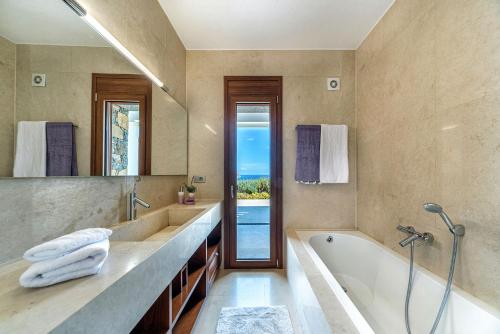 a bathroom with a tub and a sink and a shower at Elounda Lavender Villa in Elounda
