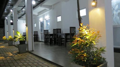 Habitación con mesa, sillas y plantas. en Senomaal Sigiri Resort en Dambulla