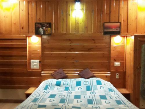 a bedroom with a bed in a room with wooden walls at Blue Lagoon Khavane, Tarkarli- Malvan in Vengurla