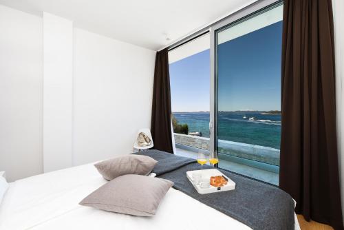 a bedroom with a bed with a view of the ocean at Villa Fuxbau Zdrelac Zadar mit Boot in Ždrelac