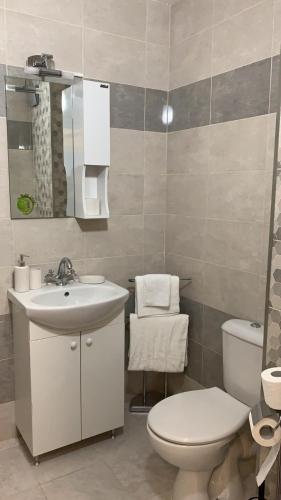a bathroom with a white toilet and a sink at ComfortApartment IGLIKA 2 in Borovets