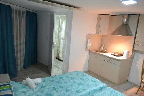 a bedroom with a blue bed and a bathroom at Honey Home by KOSTOSKI INN in Prilep