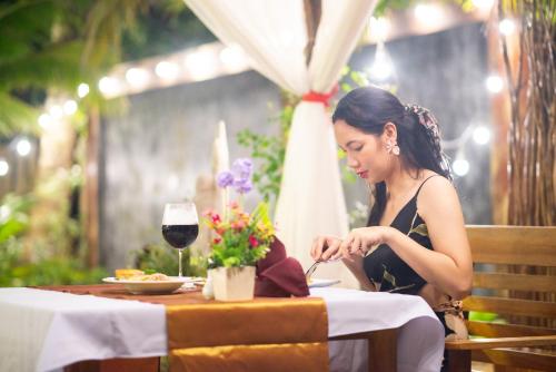 a woman sitting at a table with a plate of food at Andalay Beach Resort Koh Libong in Ko Libong