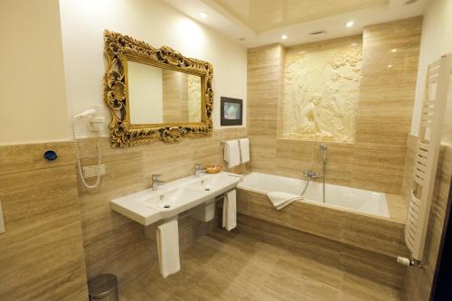 a bathroom with a sink and a tub and a mirror at Delice in Lviv
