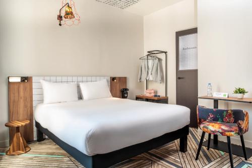 a bedroom with a large white bed and a chair at Ibis Styles Hotel Paris Gare de Lyon Bastille in Paris