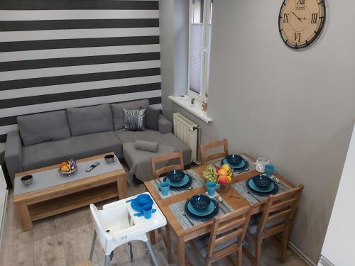 salon ze stołem i kanapą w obiekcie Apartament Na Franciszkańskiej w Szklarskiej Porębie
