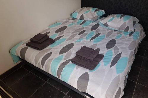 Una cama con dos toallas encima. en ST LARY-VIGNEC Joli petit appartement idéalament situé, en Vignec