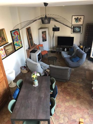 un salon avec une table, des chaises et une télévision dans l'établissement Maison Loiseau - Maison Calme au Centre de Beaune, à Beaune