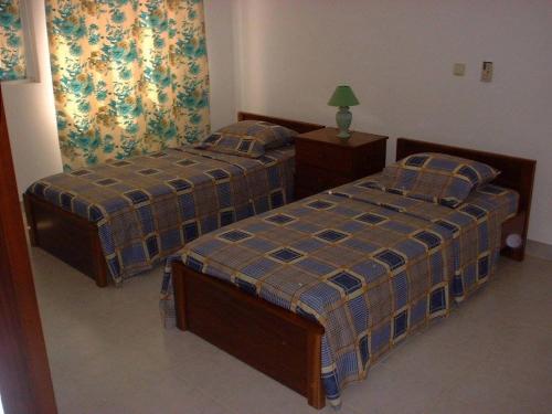two twin beds in a room with at Residencial Pôr do Sol in Porto Novo