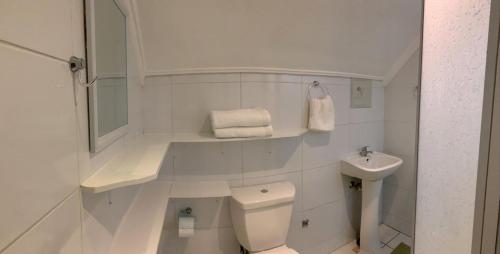 Un baño blanco con inodoro y lavabo. en La Quebrada lodge, en Papudo