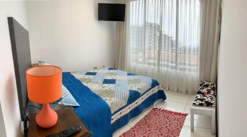 Un dormitorio con una cama y un televisor y una ventana. en La Quebrada lodge, en Papudo