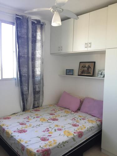 Un pequeño dormitorio con una cama con flores. en Spazio Solarium - Apartamento, en Lauro de Freitas